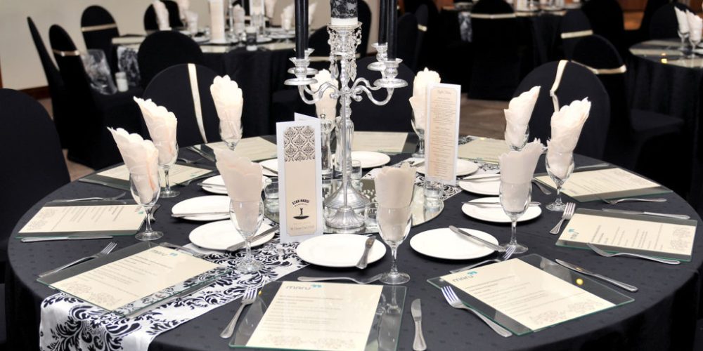 Round table set with black decor and elegant glassware