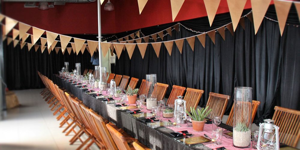 Long dining table set with potted plants and bunting