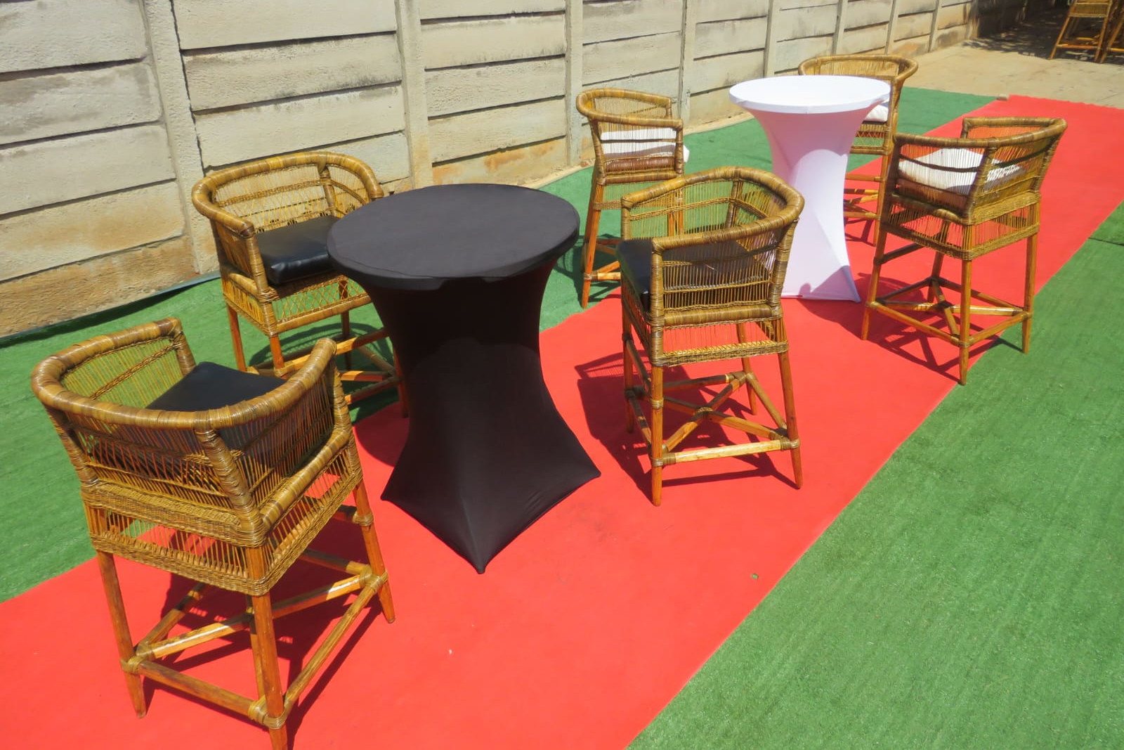 Boho-style rattan chairs and tables on red carpet