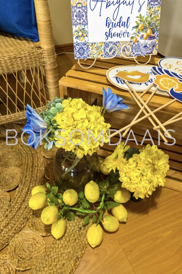 Yellow flowers and lemons arranged for a bridal shower decor setup
