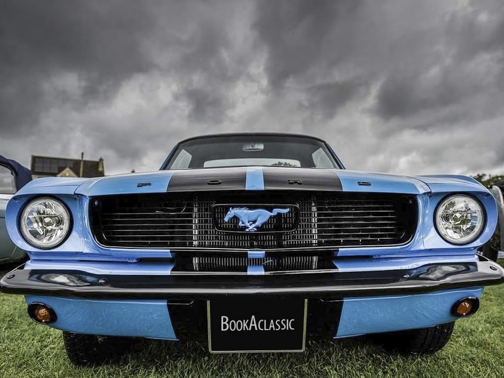 Front view of a blue Ford Mustang with black stripes