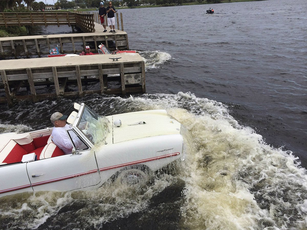 A vintage classic car driving on water