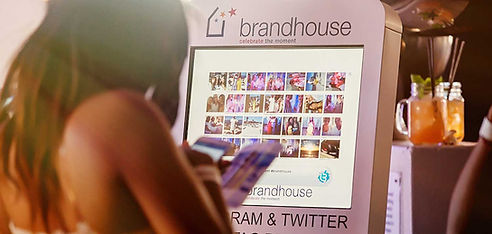 Person using a branded photo booth with displayed photos
