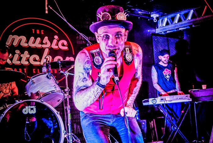 Musicians performing energetically on stage at an event.