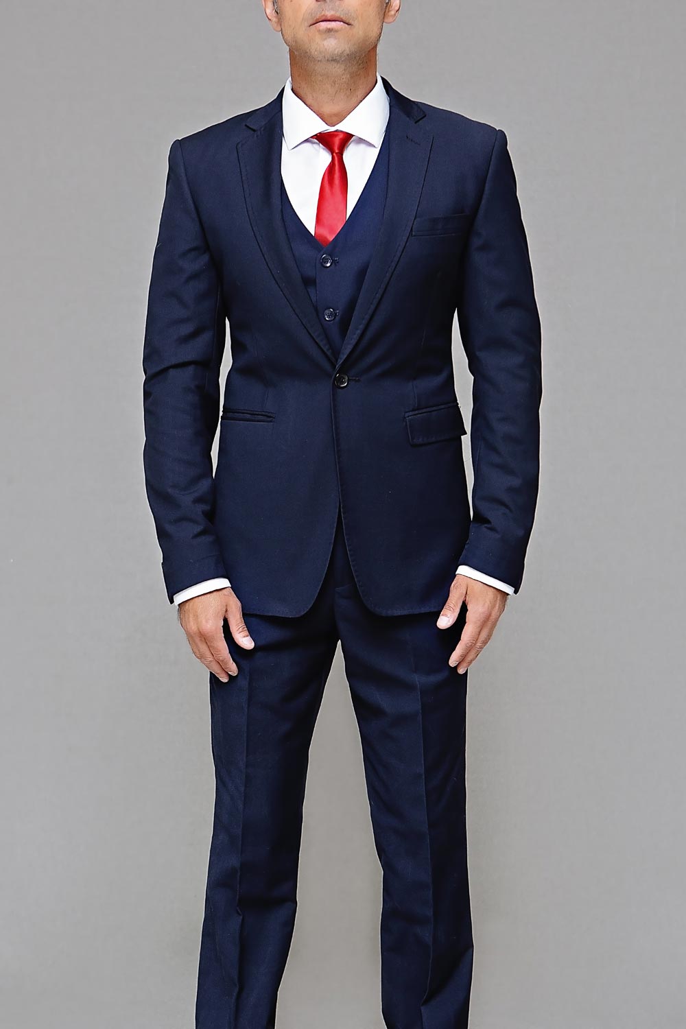 Model wearing a royal blue tuxedo with red tie