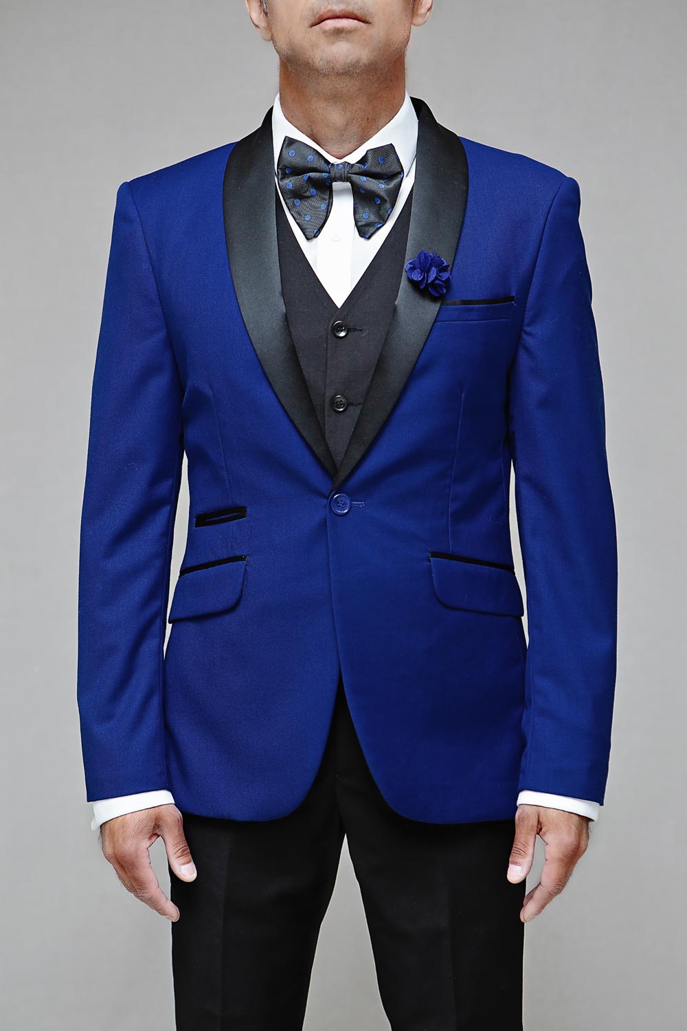 Model wearing a royal blue tuxedo with black lapels and a bow tie.