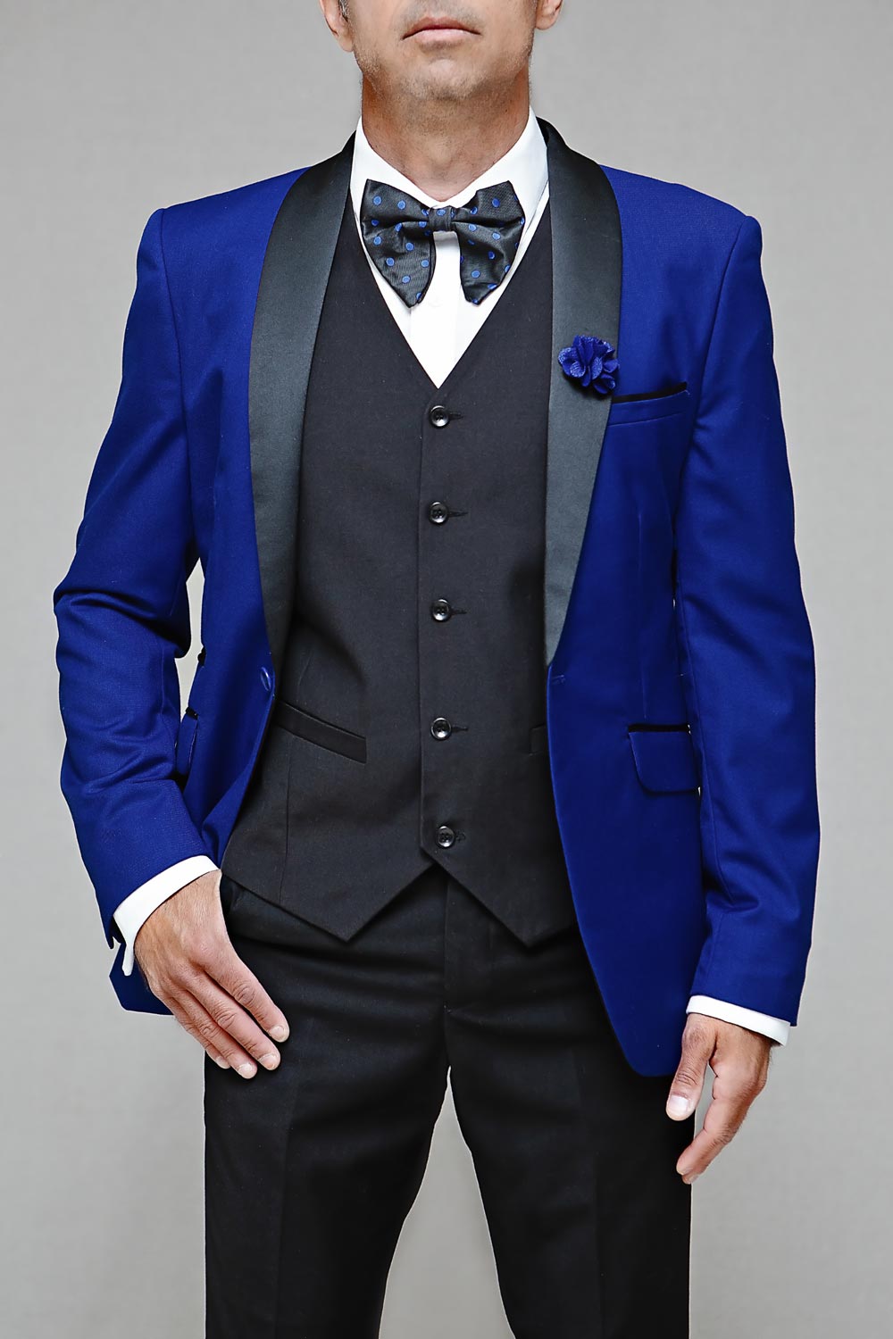 Man wearing a royal blue tuxedo with a black vest and bow tie