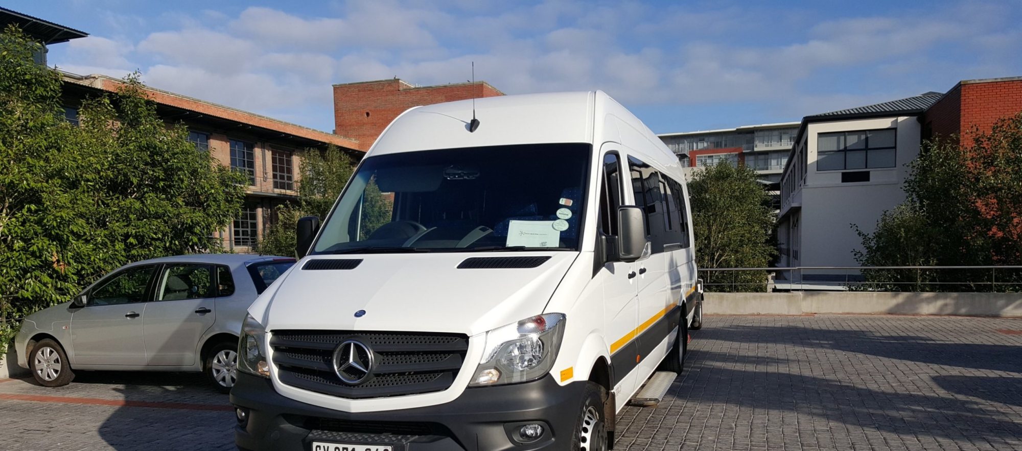 White luxury shuttle bus parked in a venue space.
