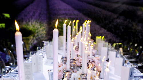 Candlelit table setting with flowers and lavender backdrop