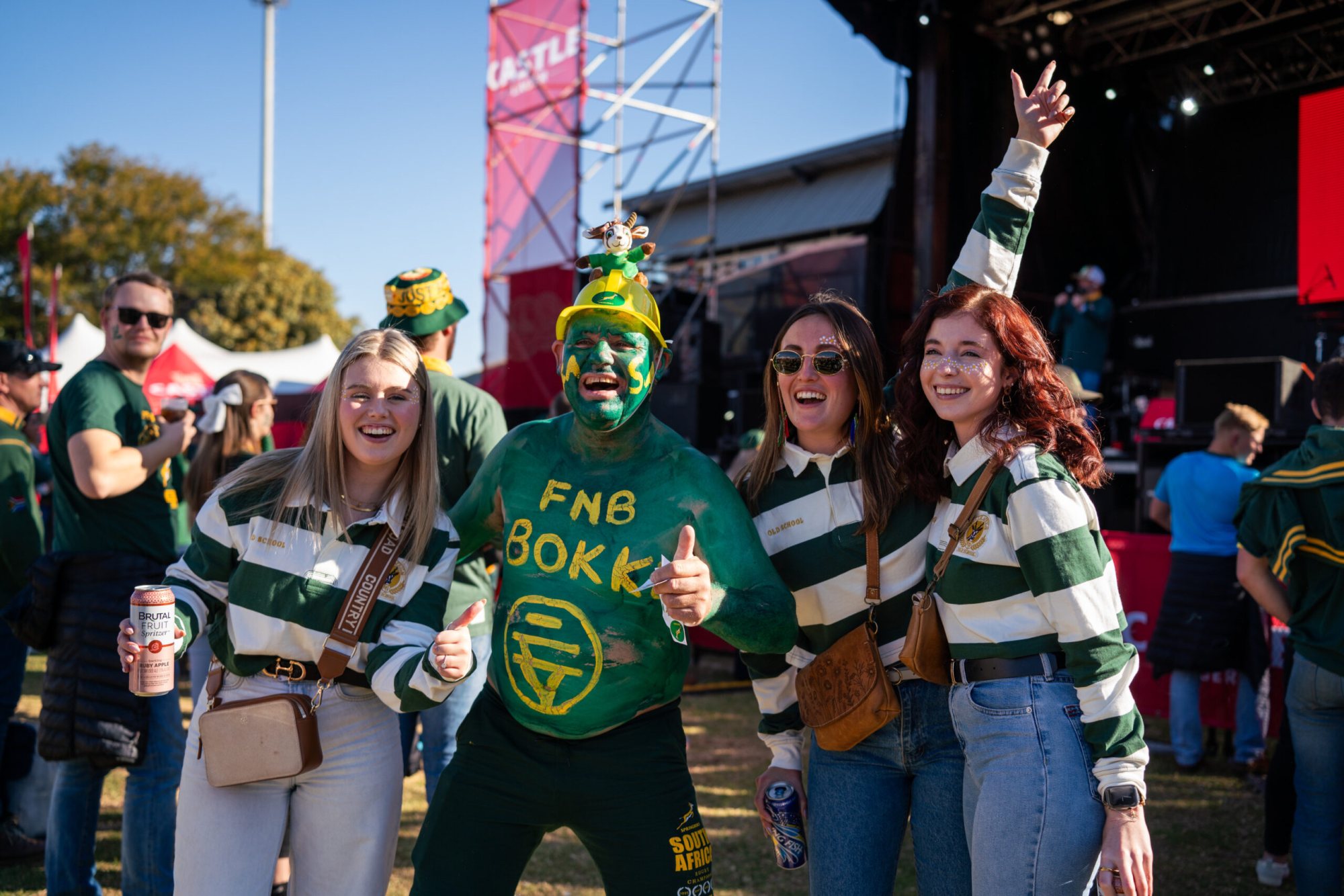Group of fans in green and gold, one painted green.