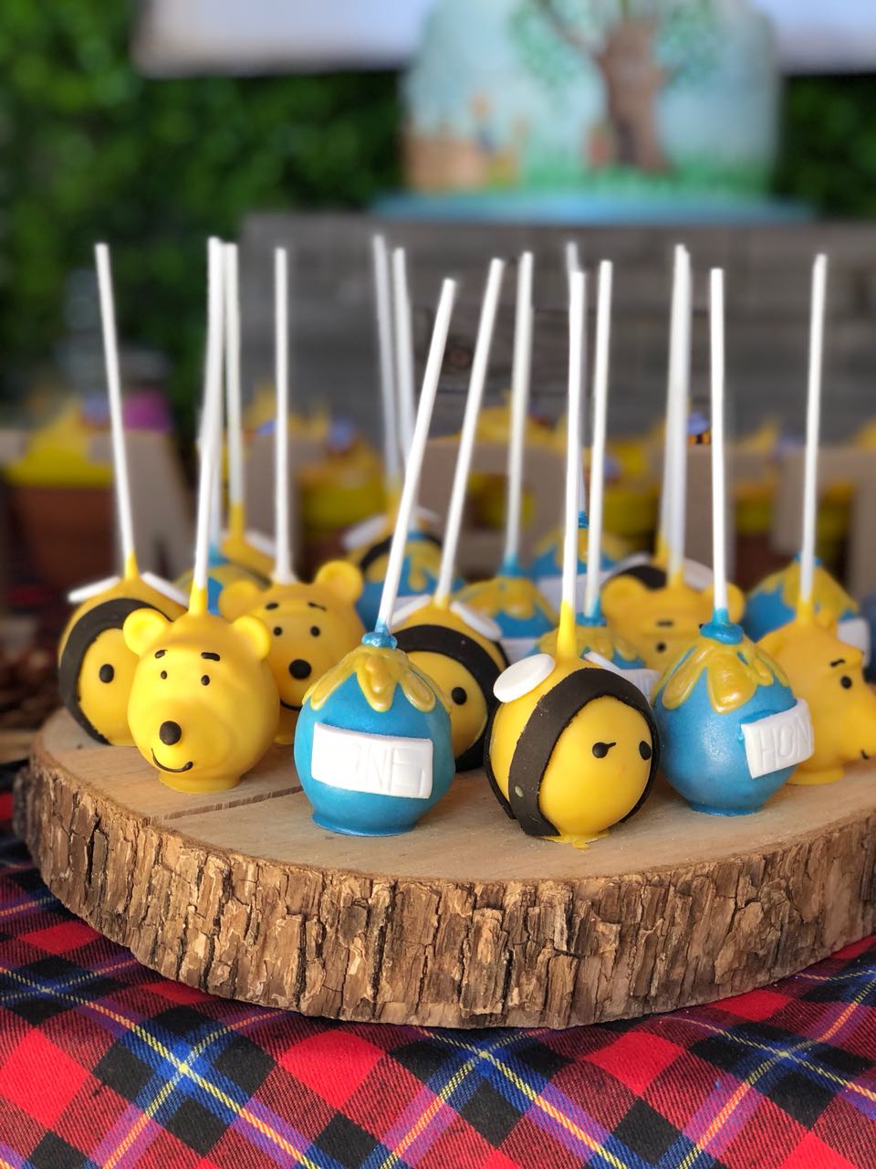 Colorful themed cake pops on a wooden platter.