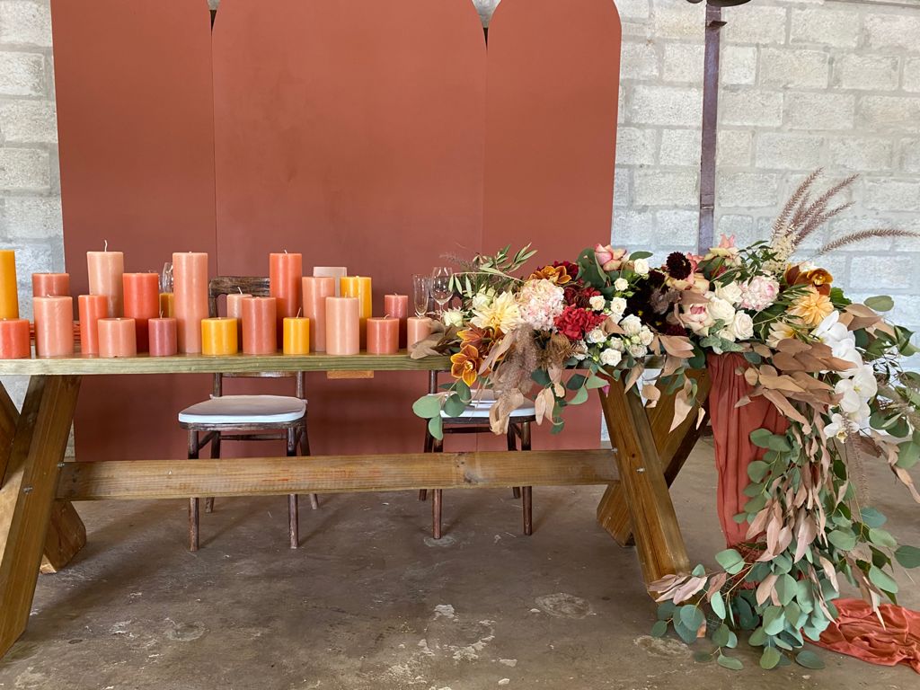 Table arrangement featuring colorful pillar candles and floral decor