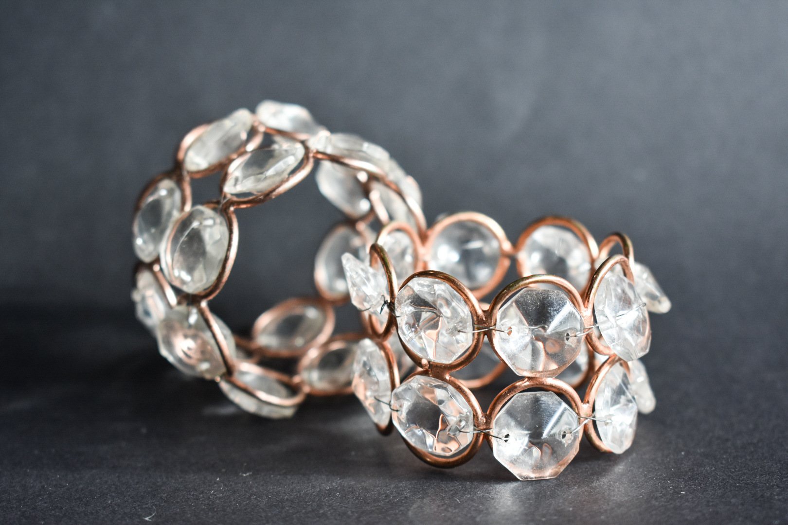 Two crystal napkin rings with copper accents