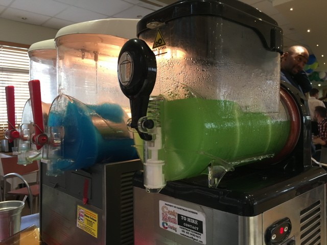 Two slushie machines with blue and green slushie flavors