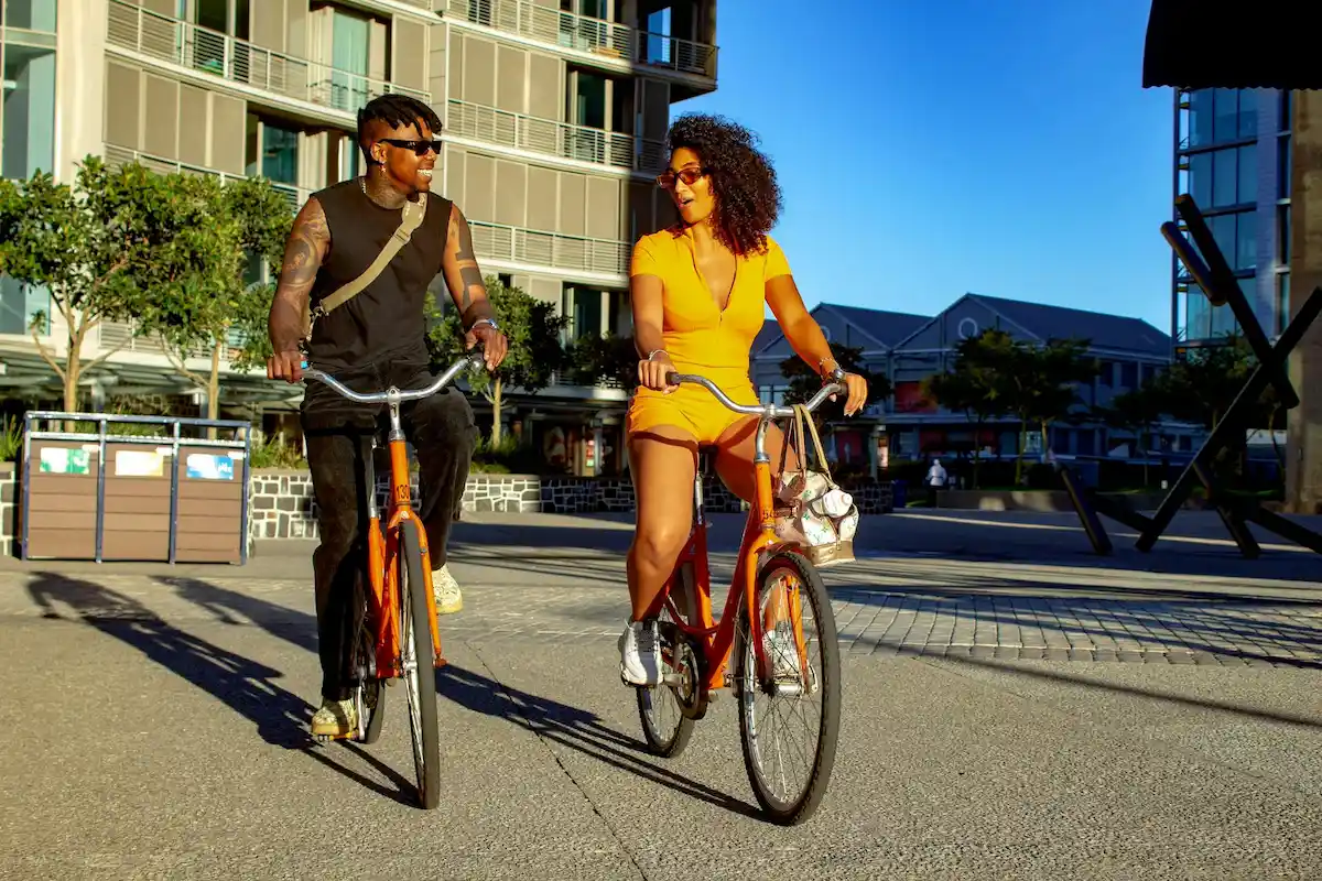 Two people biking in a sunny urban environment
