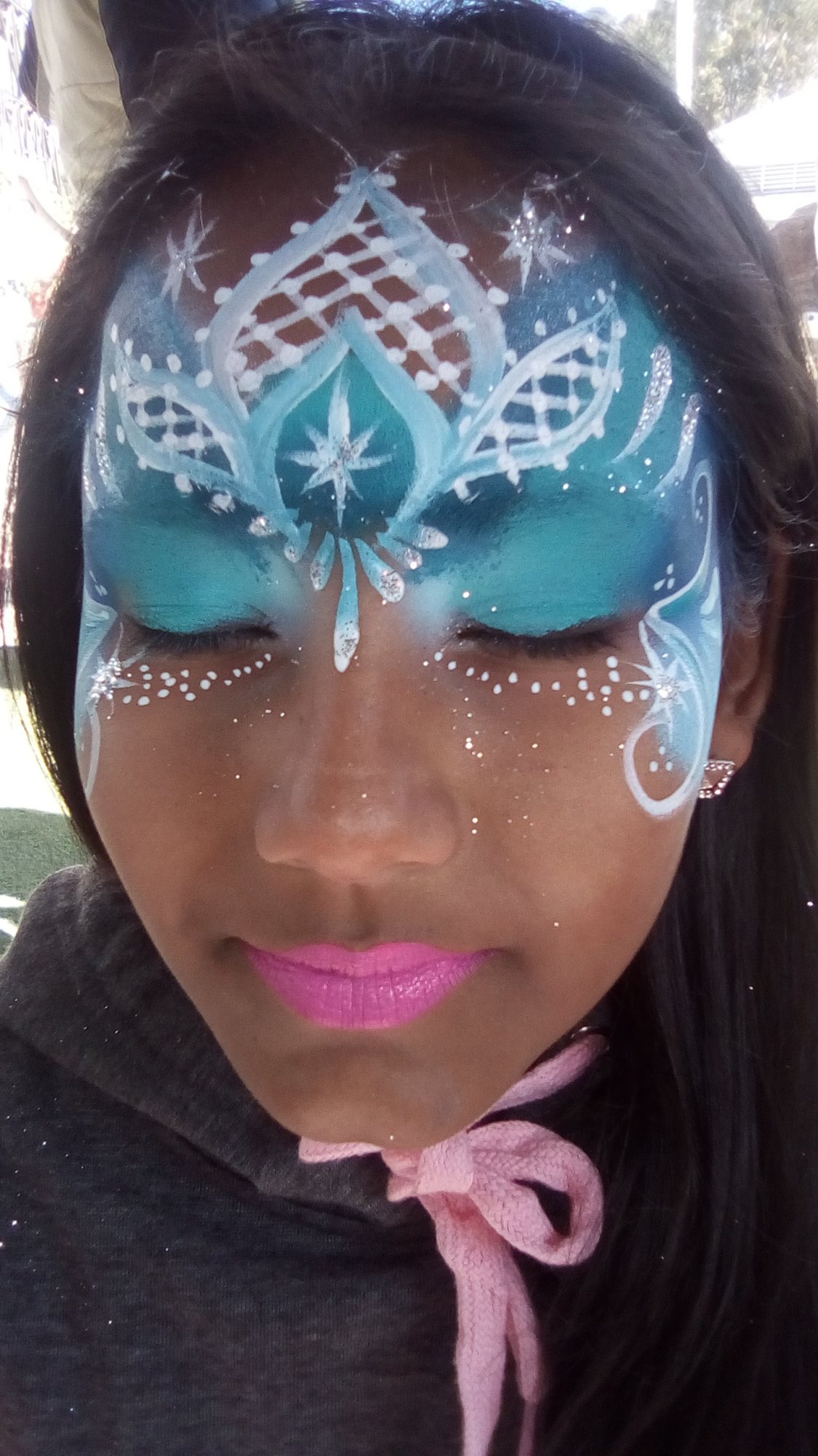 Child with intricate blue and white face painting design