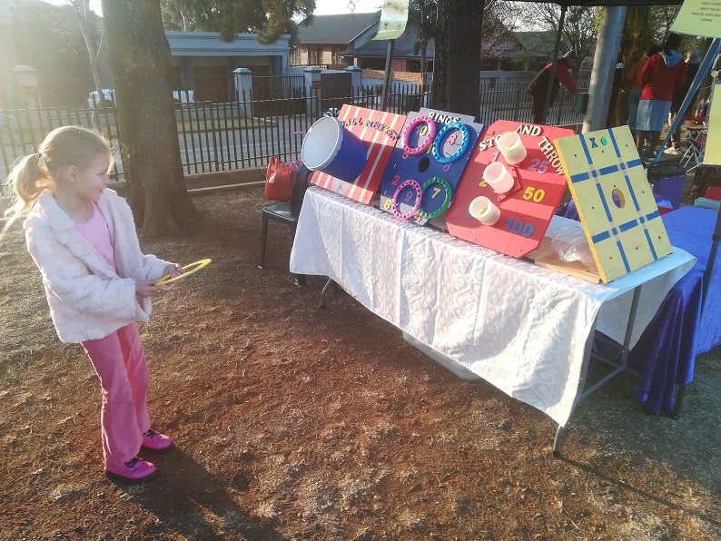 Child playing Ring Toss game with colorful targets