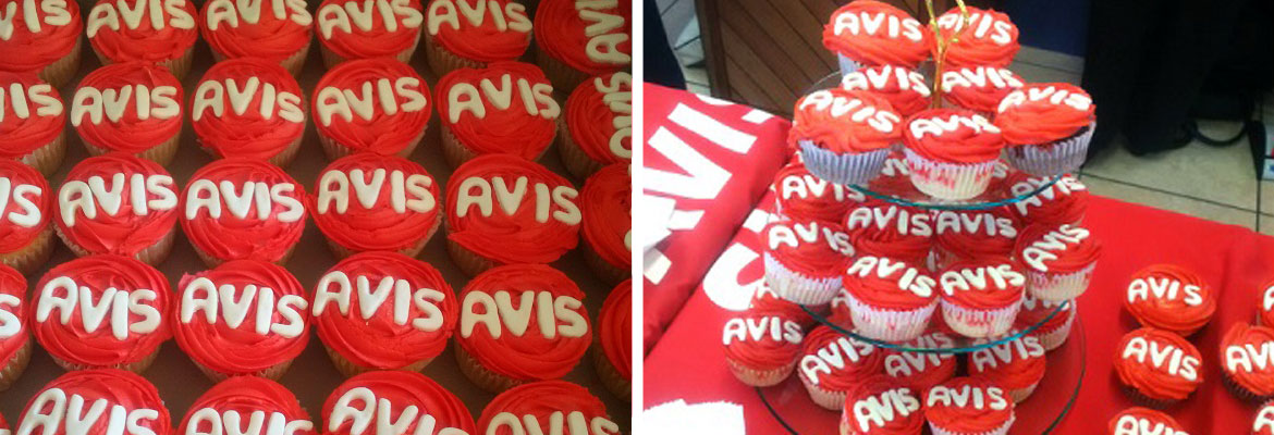 Red cupcakes with white 'AVIS' icing on display.