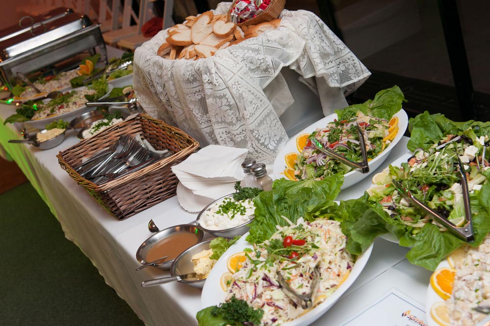 A buffet table with salads and bread on display