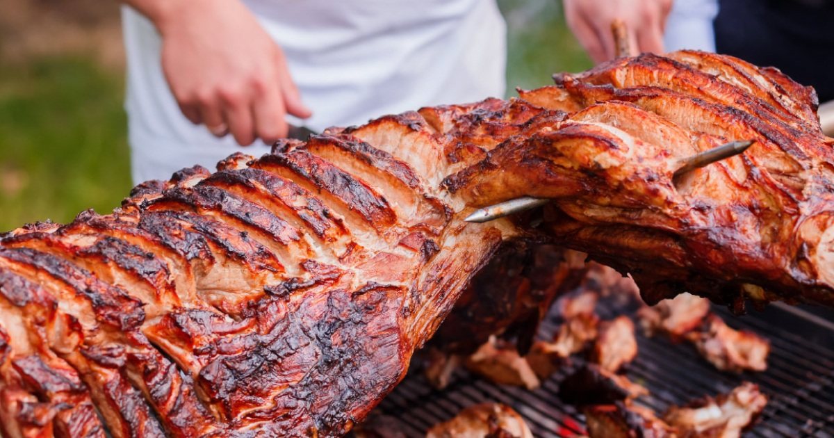 Spit-roasted whole lamb on a grill