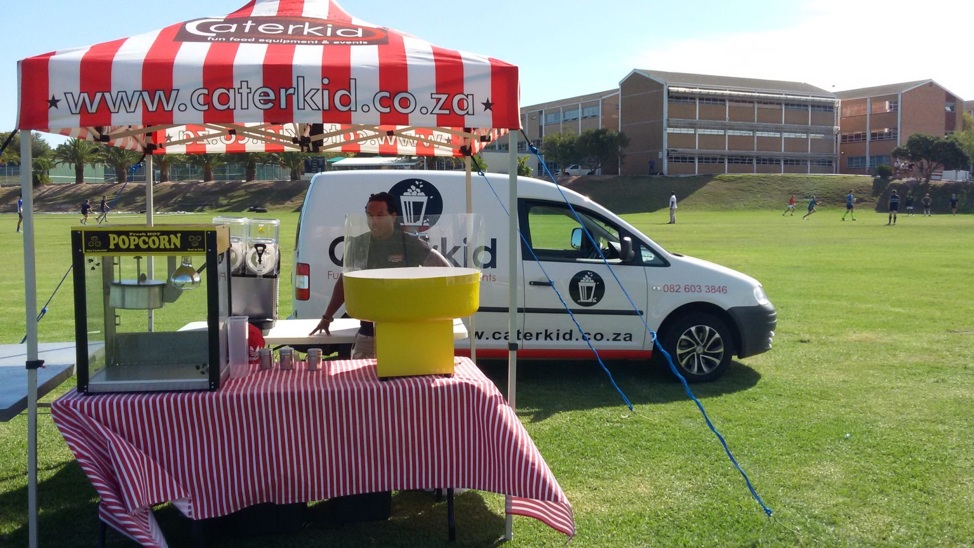 Popcorn machine and vendor under striped gazebo