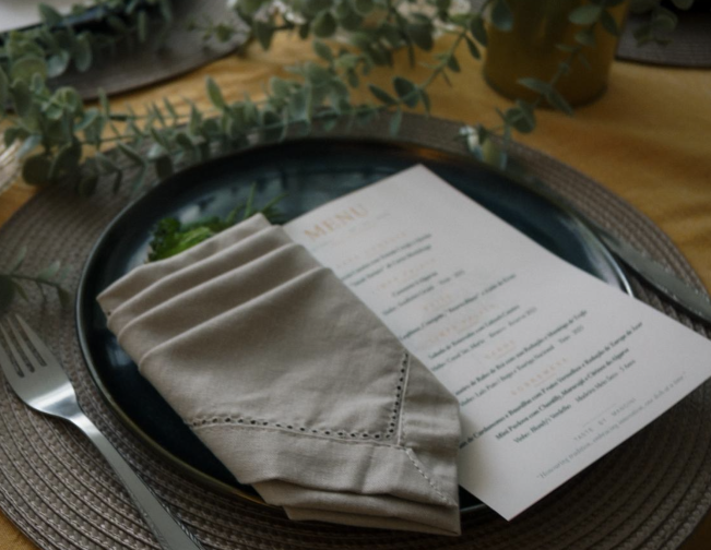 A neatly arranged table setting with a menu and napkin