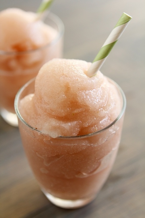 Two glasses of pink slush with green straws