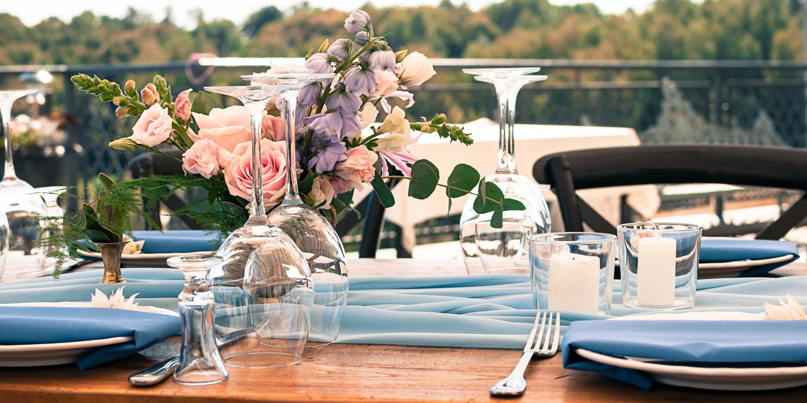 Table setting with flowers, glasses, and blue fabric