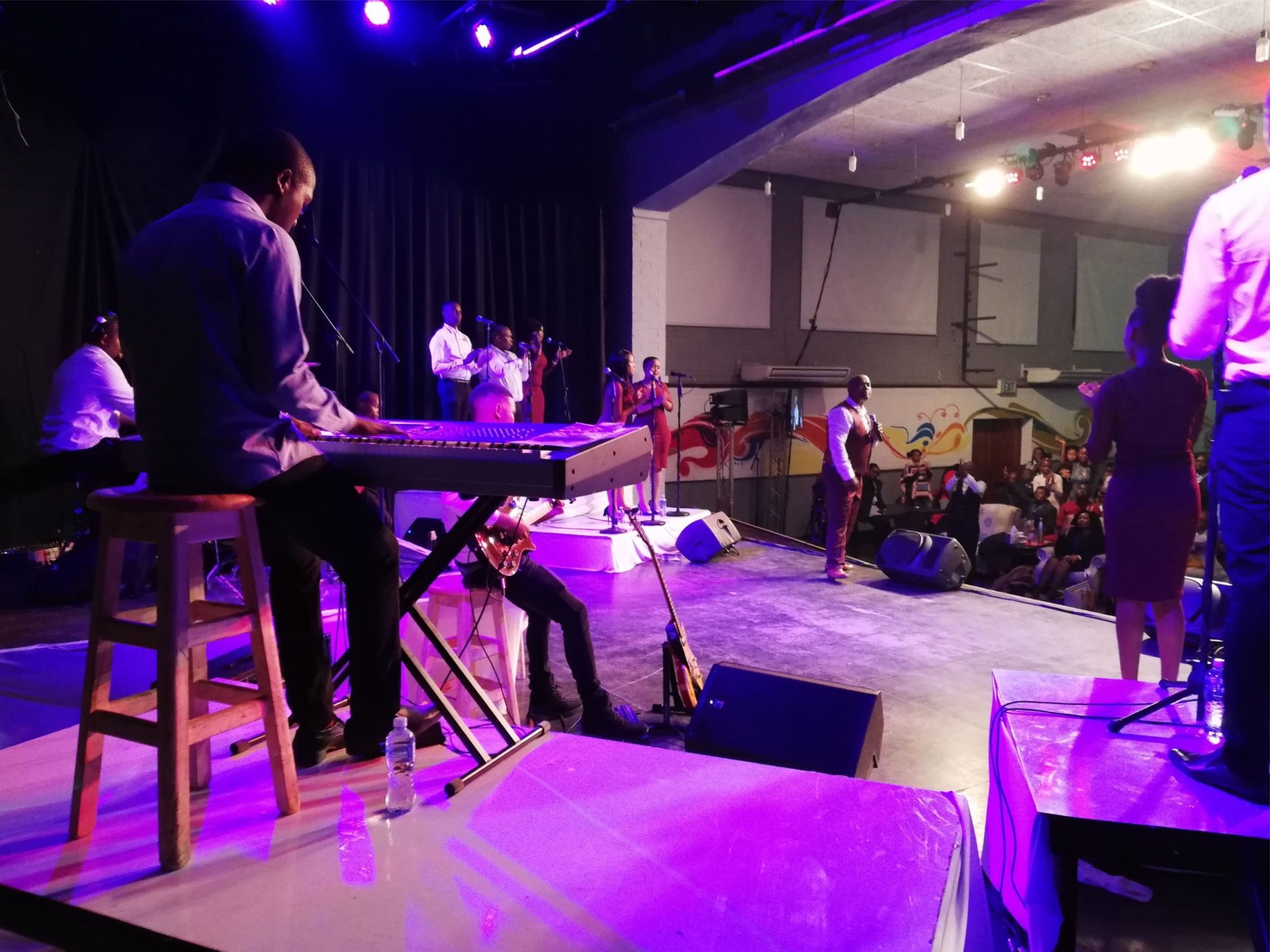 Stage with performers, musicians, and an audience