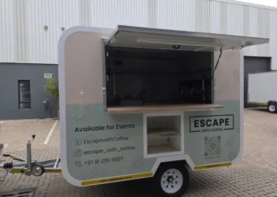 Mobile coffee trailer with open serving area and signage