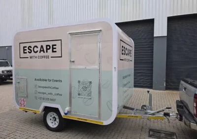 Mobile coffee trailer with branding parked in an outdoor setting