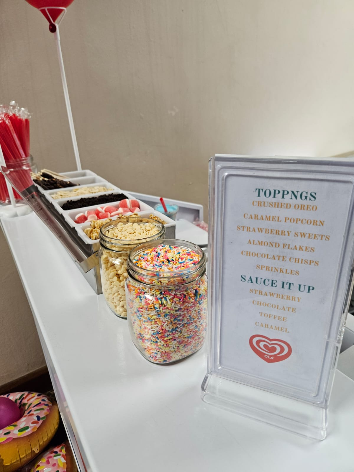 Dessert toppings station with jars of sprinkles and sweets