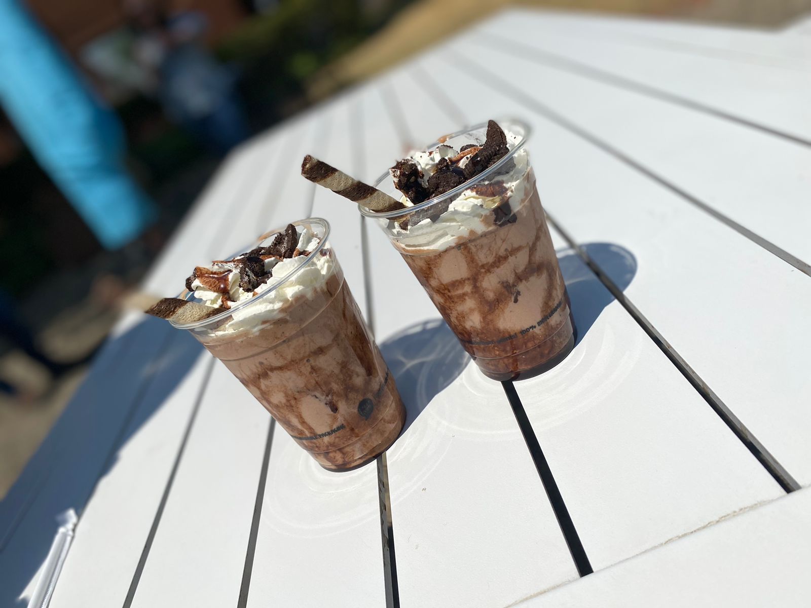 Two bubble tea cups with chocolate and whipped cream