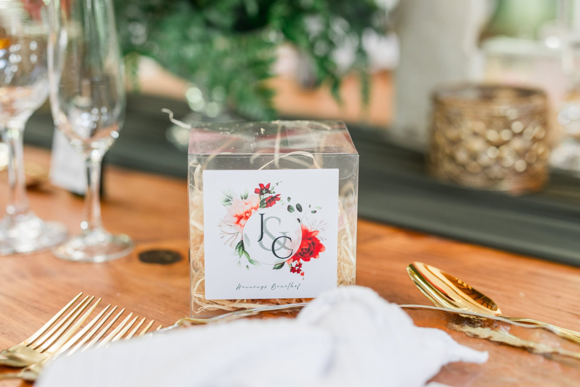 Clear box containing personalized table favor with floral design