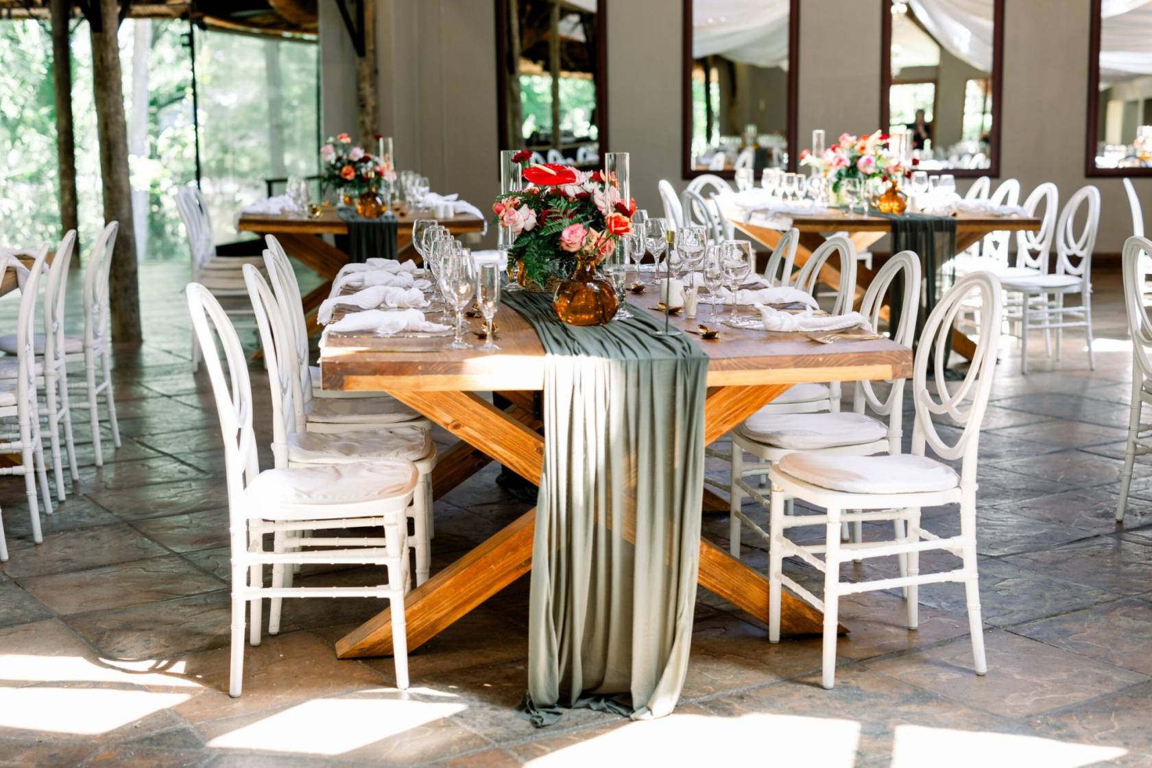 Dining setup with wooden tables and floral centerpieces