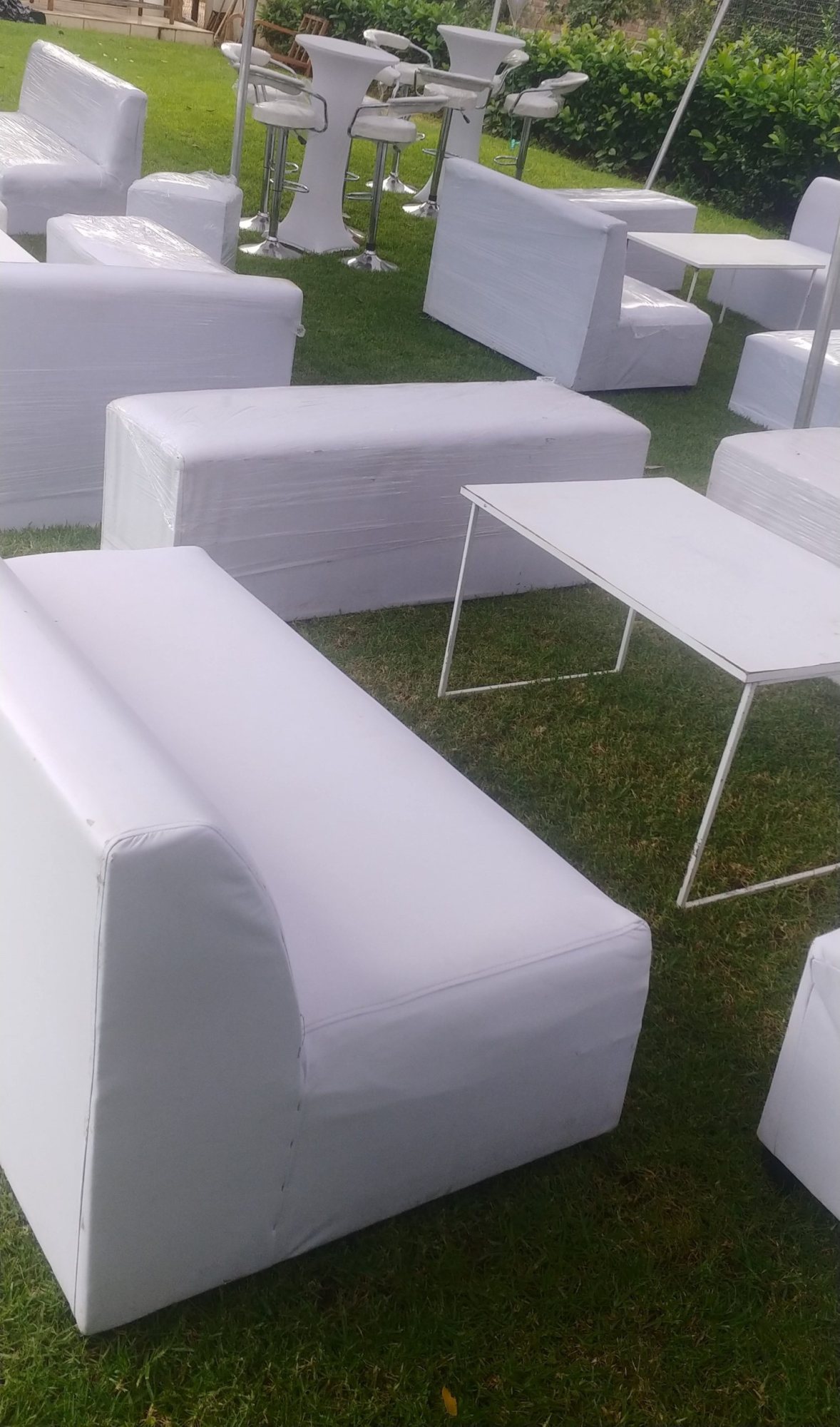 Modern white lounge furniture setup on green grass