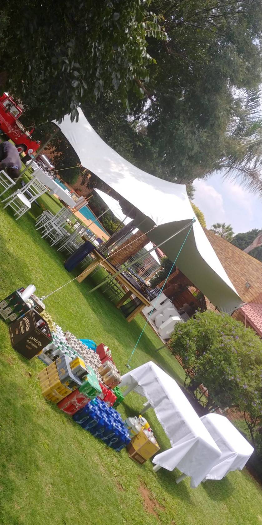 Stretch tent setup with chairs and drinks on grass