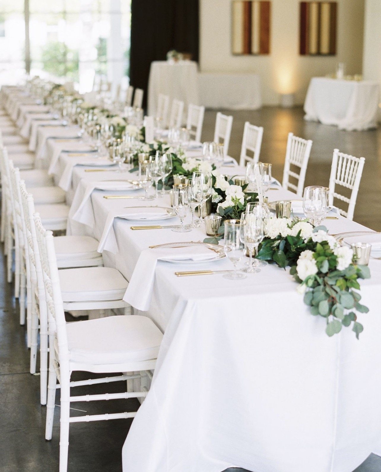 Long table with white linens and floral centerpieces