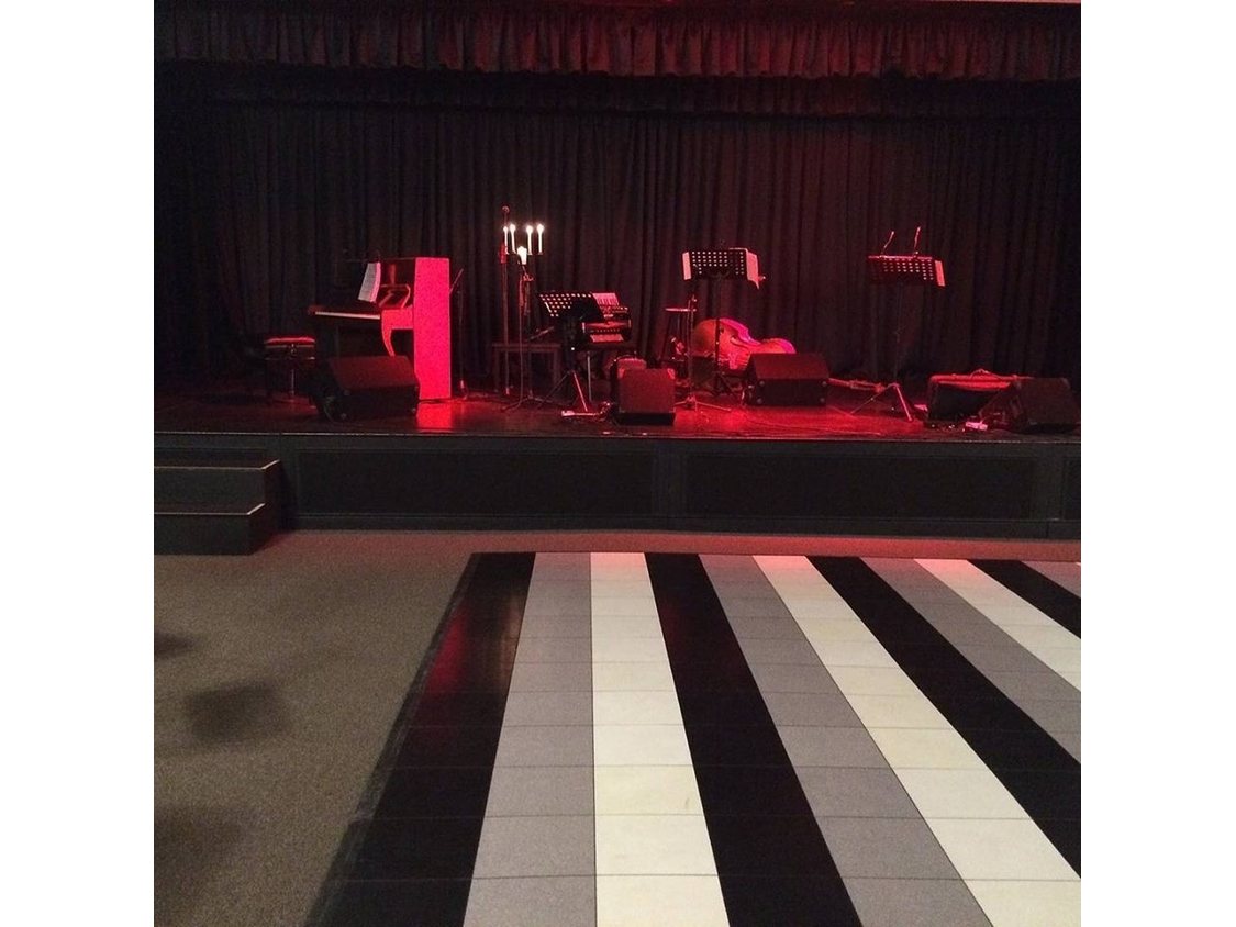 Black and white checkered dance floor in front of a stage.