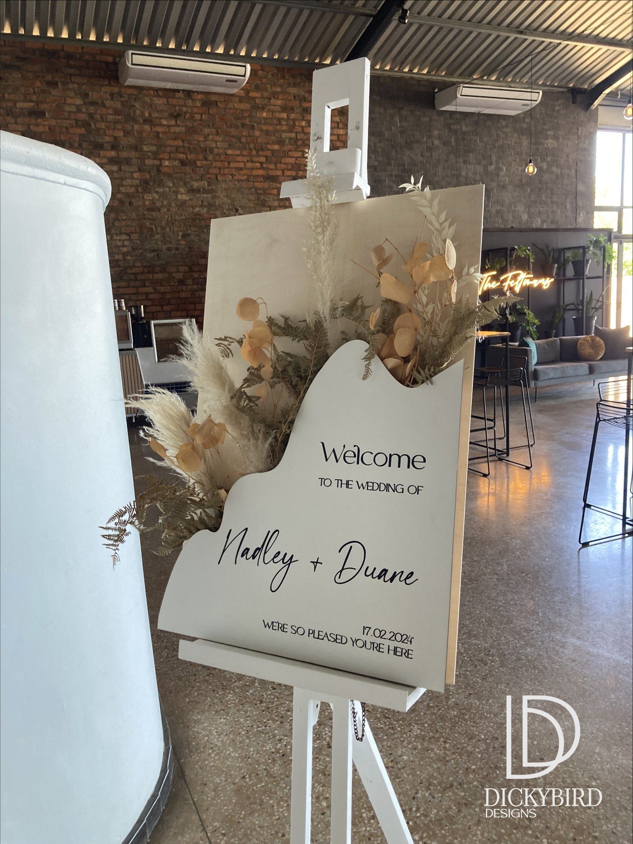 Wooden welcome sign for a wedding with dried flowers