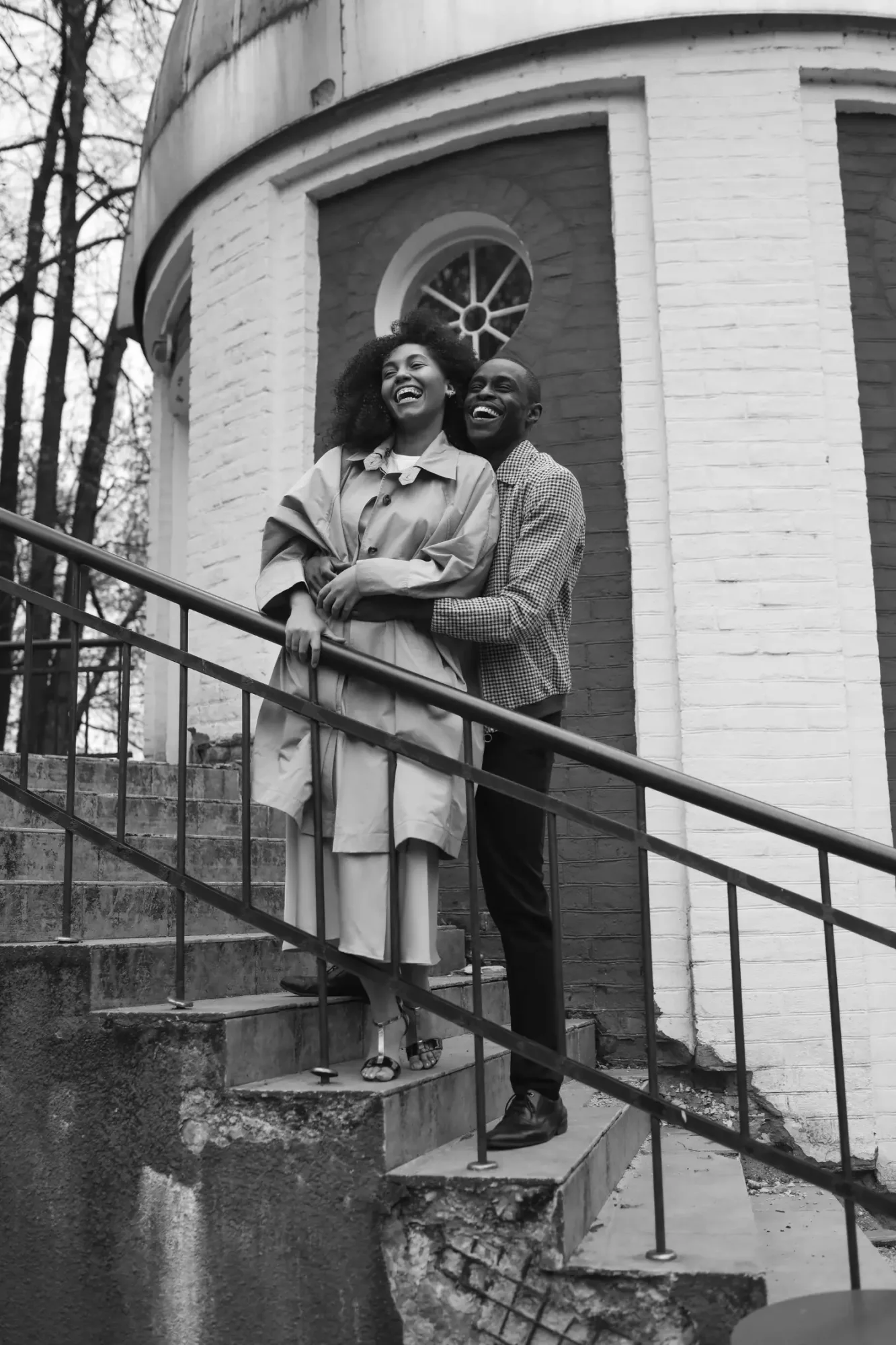 Couple smiling together on outdoor steps.