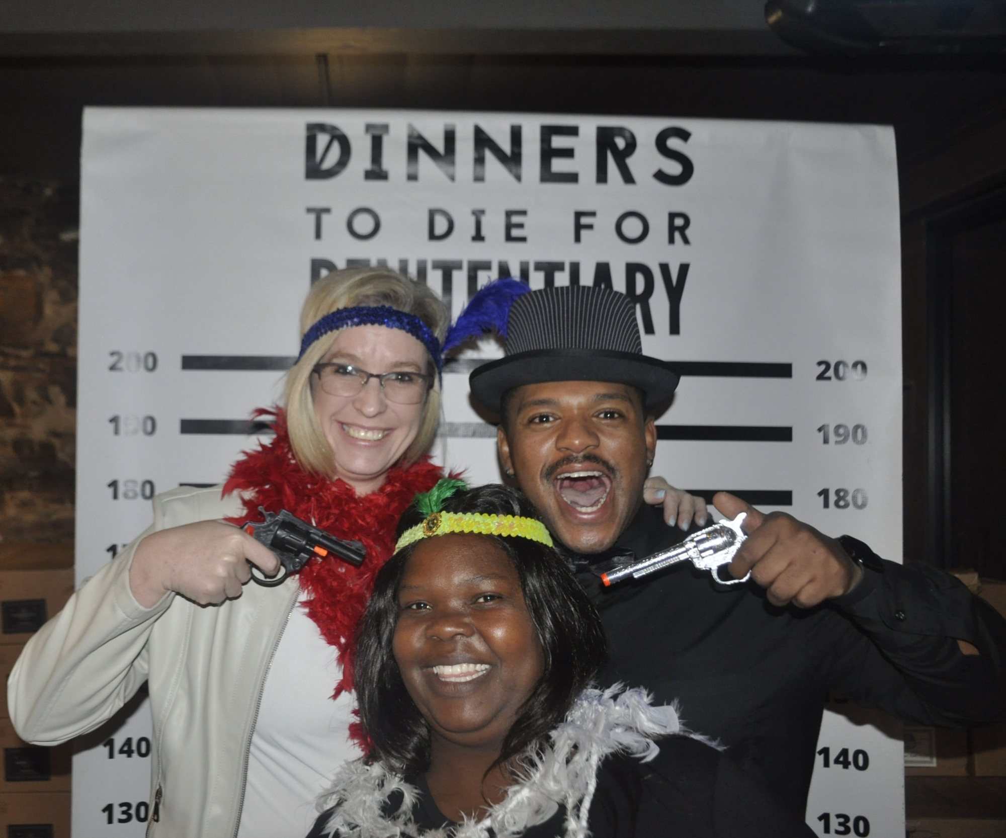 Guests dressed in costume holding toy guns for a murder mystery event