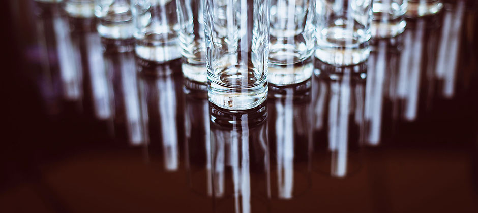 Arranged crystal-clear glassware on a reflective surface
