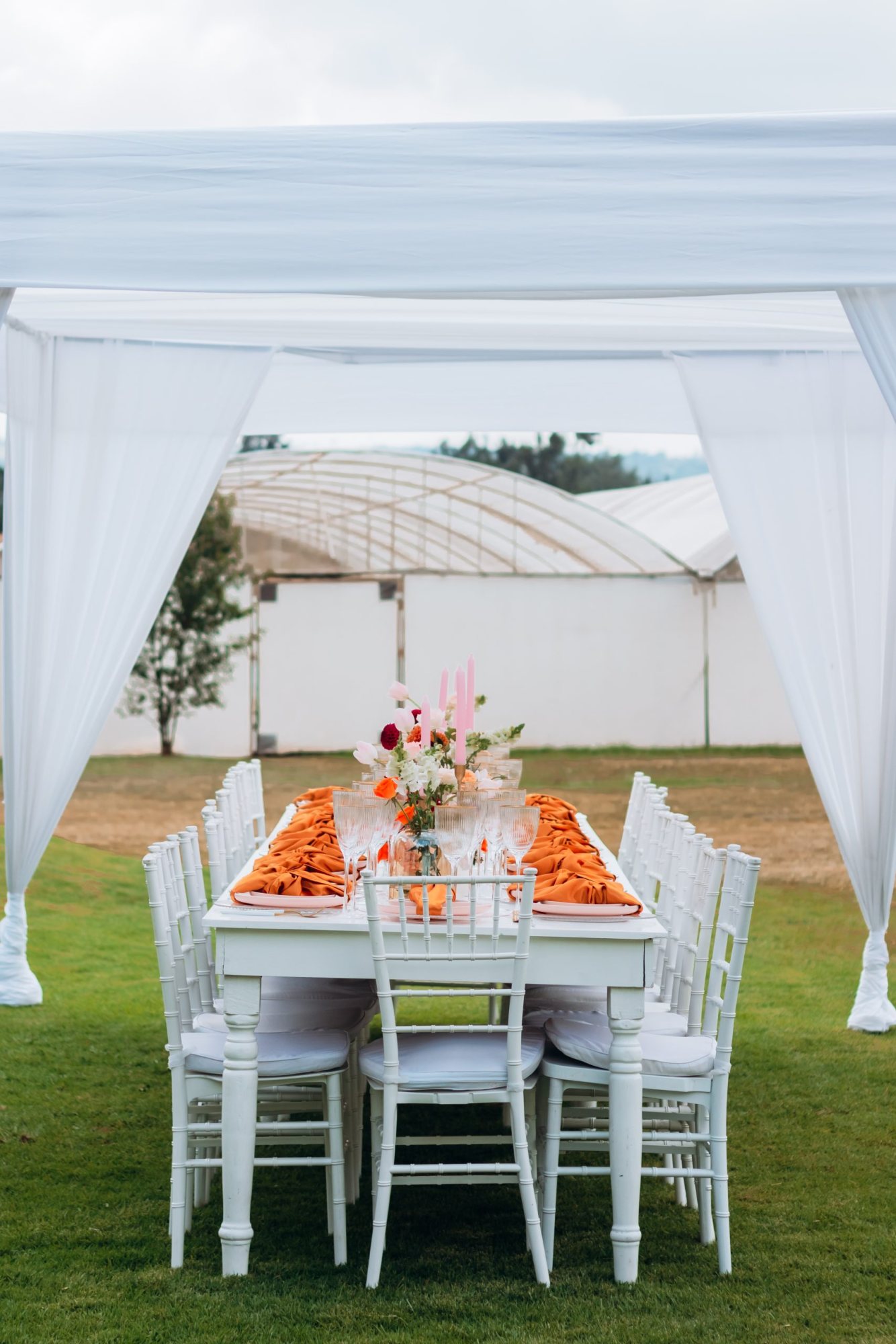 Outdoor dining table with orange decor and white chairs
