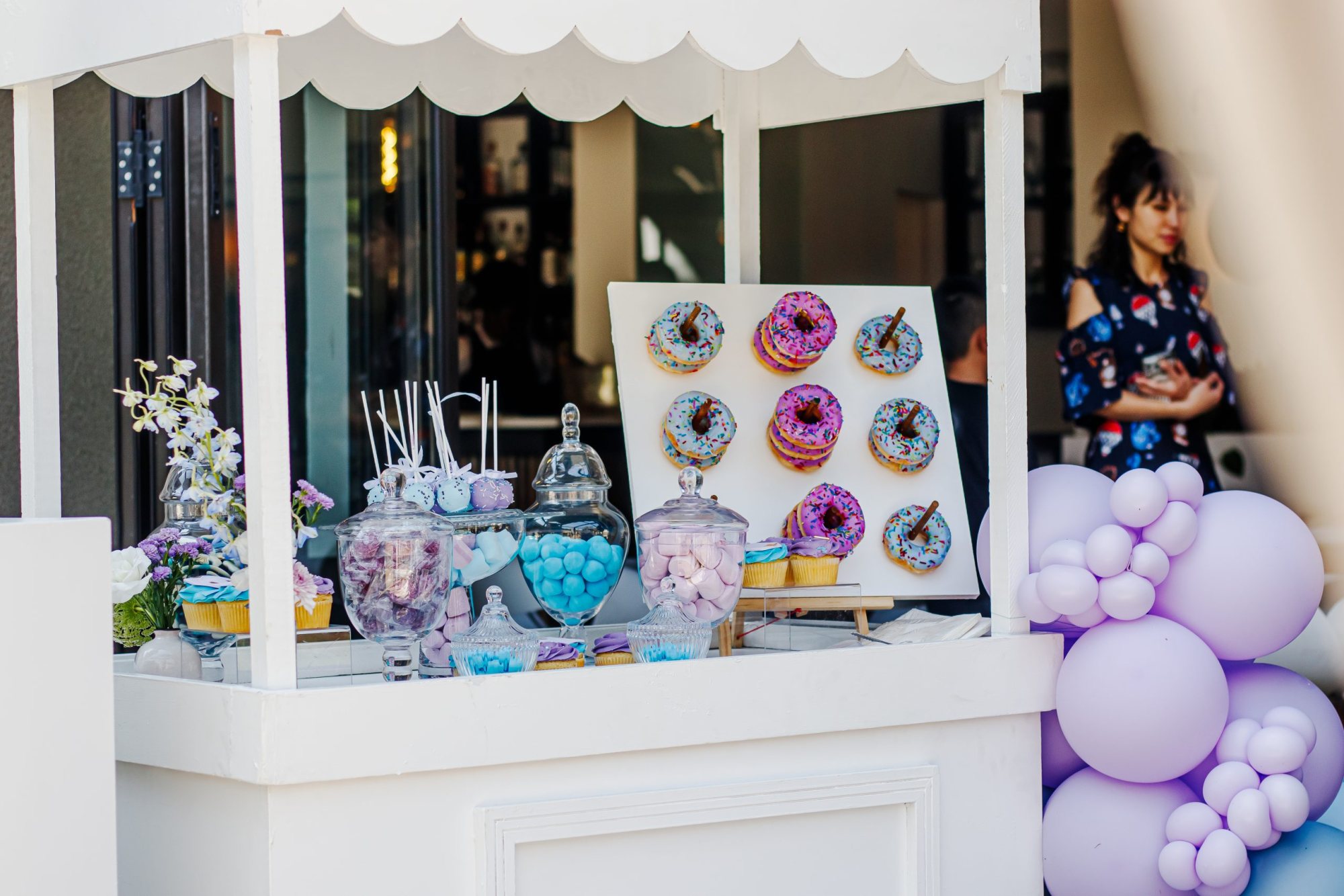 Colorful donuts displayed on a wall with sweet treat jars