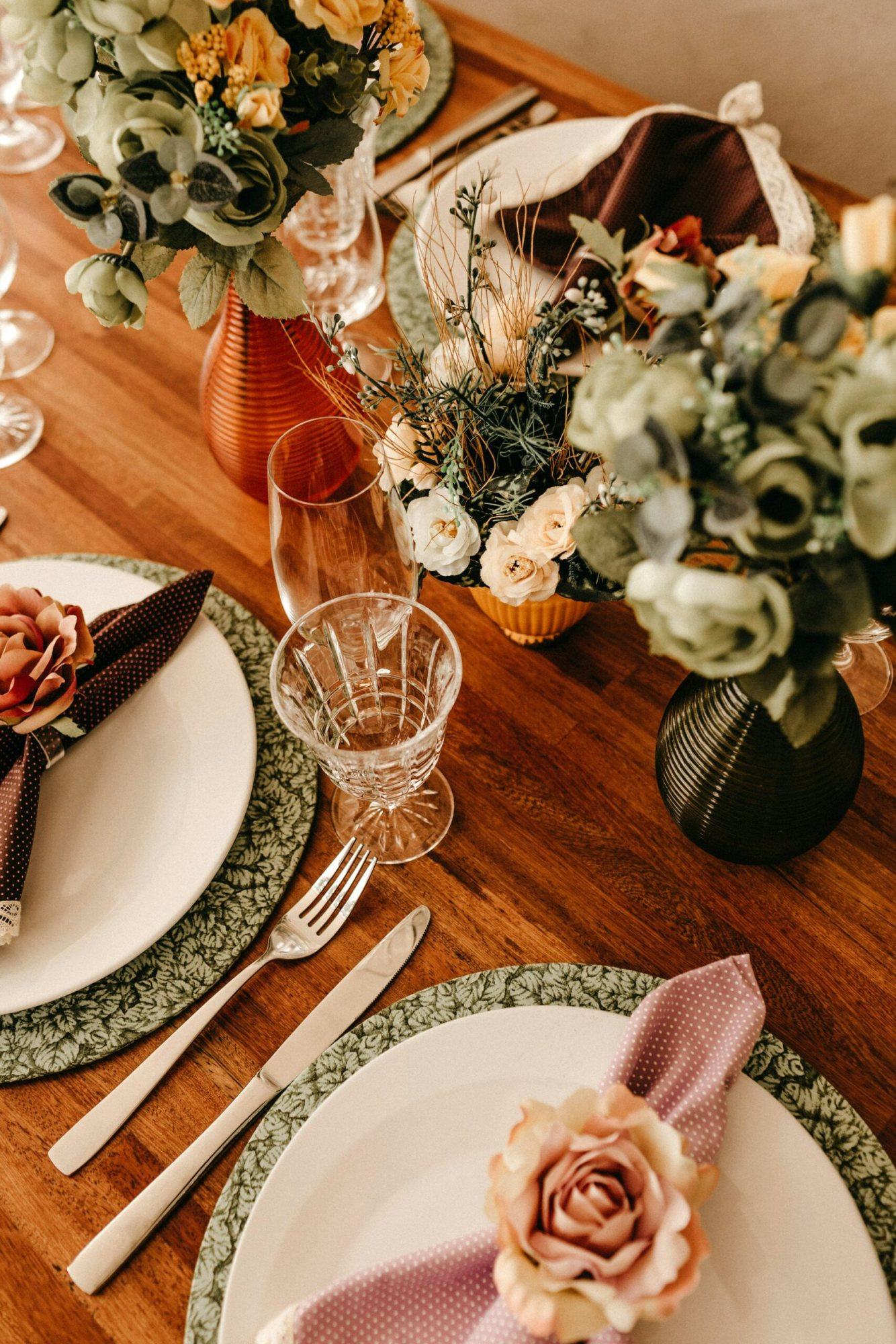 Decorated dining table with floral arrangements and elegant tableware.