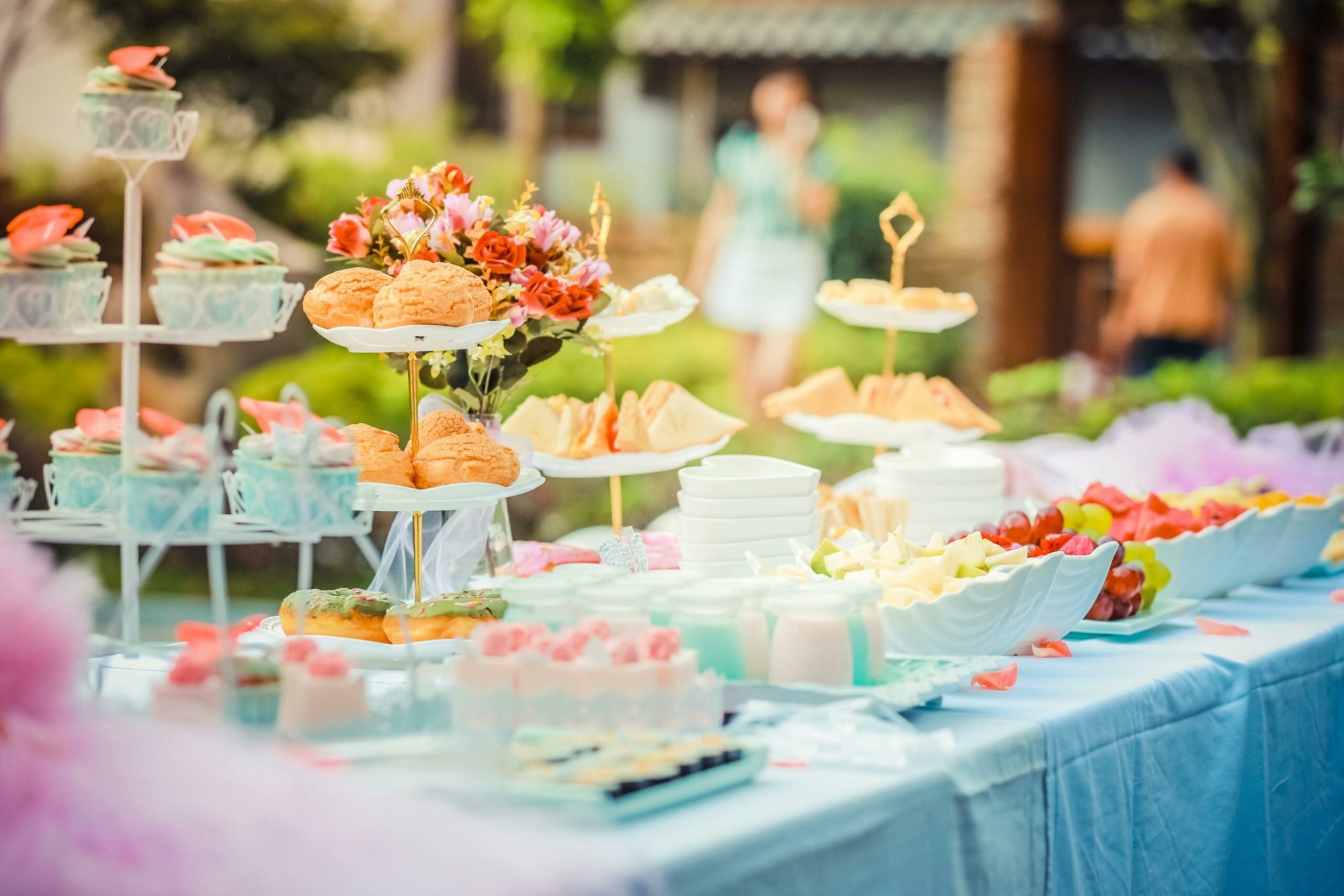 A table filled with assorted desserts and snacks in a garden setting.