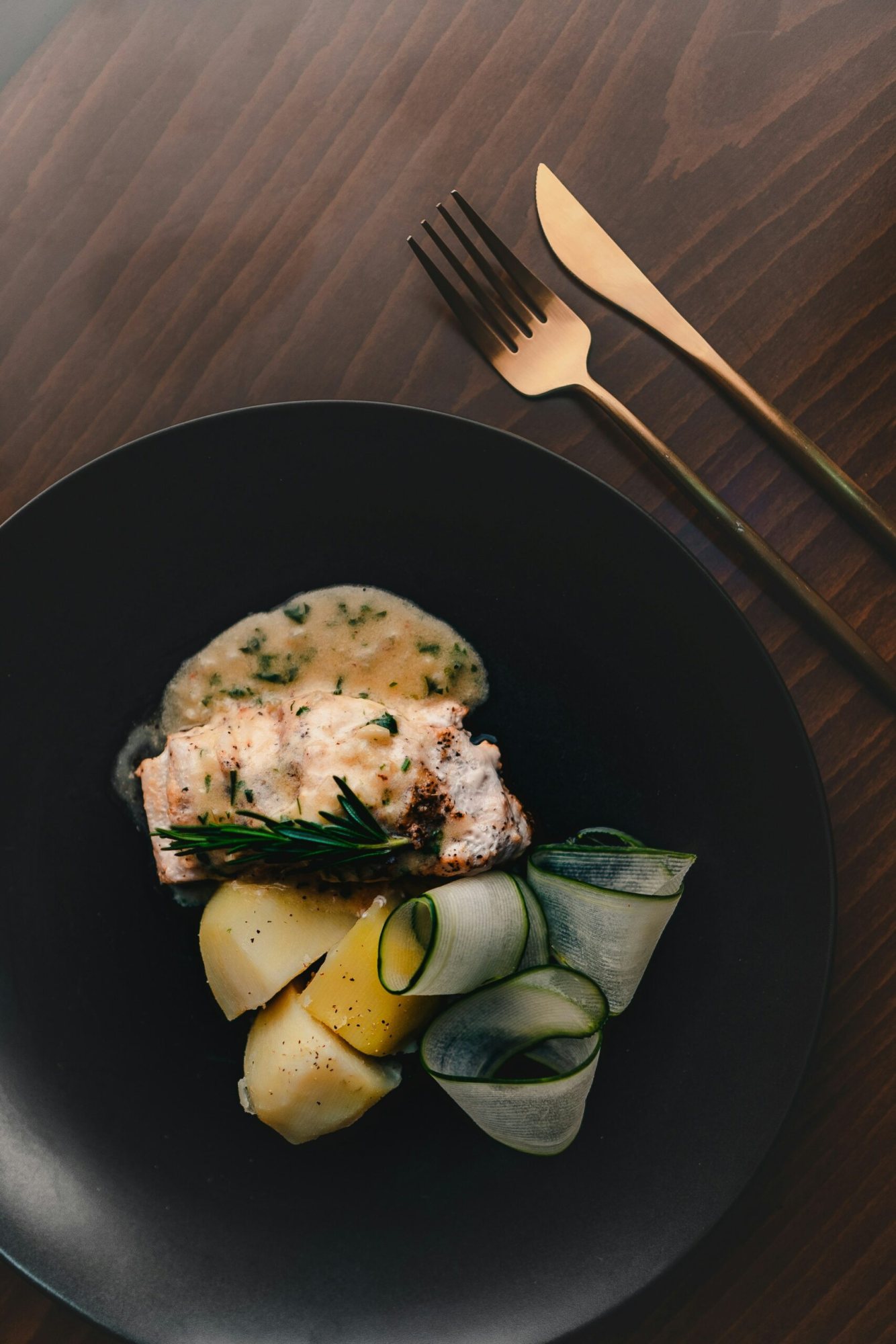 Gourmet dish featuring fish, potatoes, and cucumber ribbons