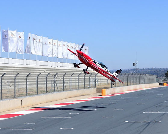 Stunt airplane performing near racetrack