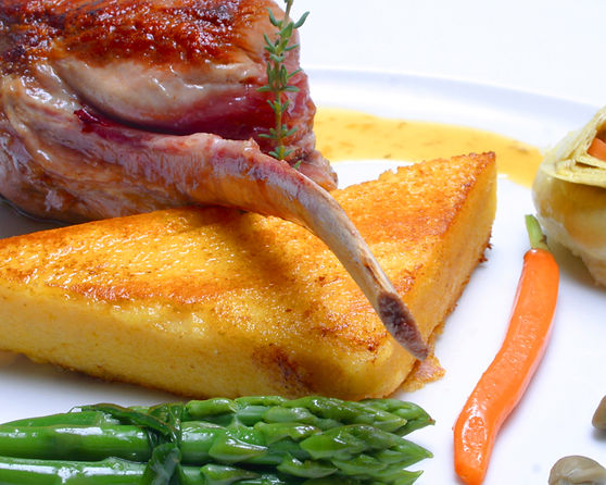 Plate of gourmet lamb cutlet with polenta and vegetables